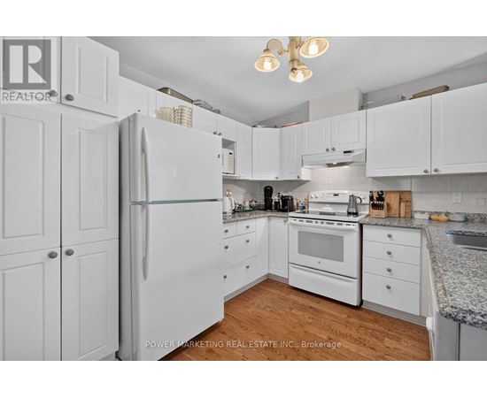 A kitchen with white cabinets and appliances.