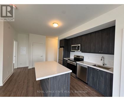 A kitchen with dark wood cabinets and a white island.