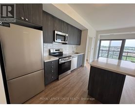 A kitchen with a refrigerator, microwave, oven, and sink.