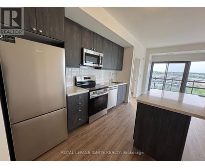 A kitchen with a refrigerator, microwave, oven, and sink.