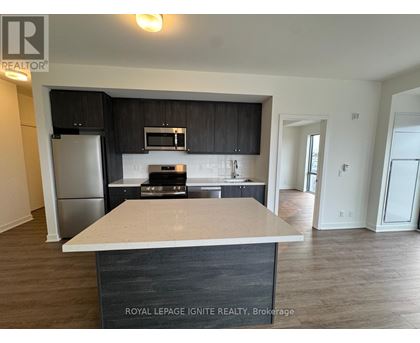 A kitchen with a white counter top and black cabinets.