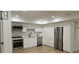 A modern kitchen with white cabinets and stainless steel appliances.