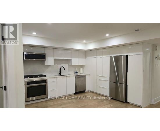 A modern kitchen with white cabinets and stainless steel appliances.