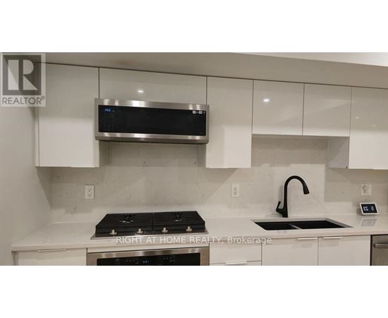 A modern kitchen with a stove top oven and a microwave above it.