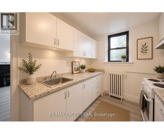 A kitchen with white cabinets and a marble countertop.