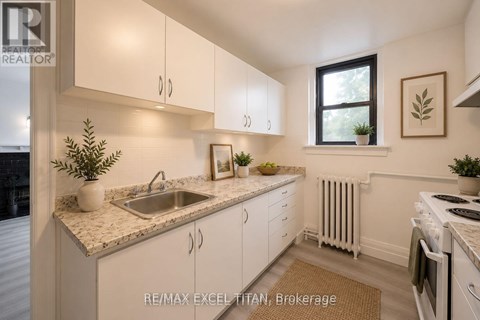 A kitchen with white cabinets and a marble countertop.