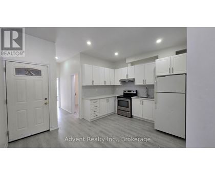 A white kitchen with a white door and white cabinets.