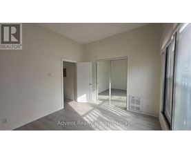 A room with a white door and a white wall with a window.