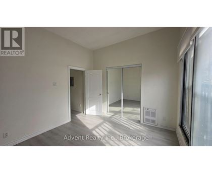A room with a white door and a white wall with a window.