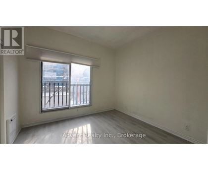 A room with a window and a sign that says Advent Realty Inc., Brokerage.