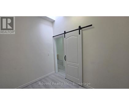 A white door with a black handle is in a room with white walls.