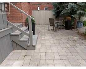 A patio with a table and chairs is surrounded by a brick wall.