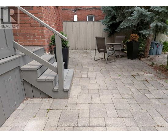 A patio with a table and chairs is surrounded by a brick wall.