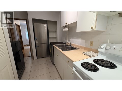 A kitchen with white appliances and a stove top oven.