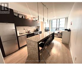 A kitchen with a refrigerator, stove, and sink.
