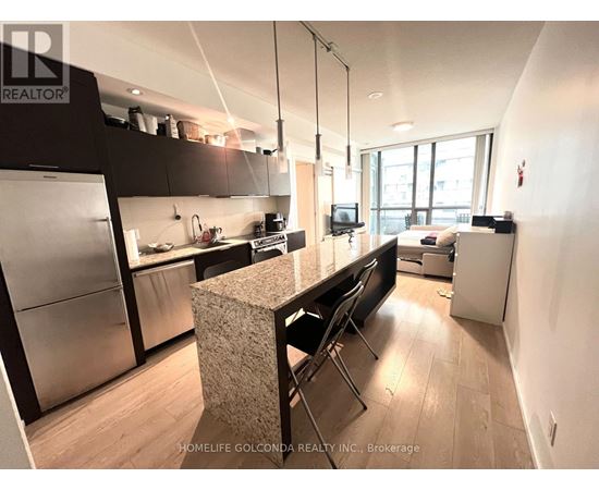 A kitchen with a refrigerator, stove, and sink.