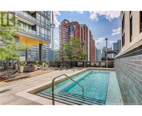 A pool surrounded by buildings and trees.