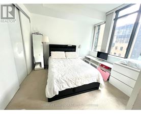 A bedroom with a large bed and a window.
