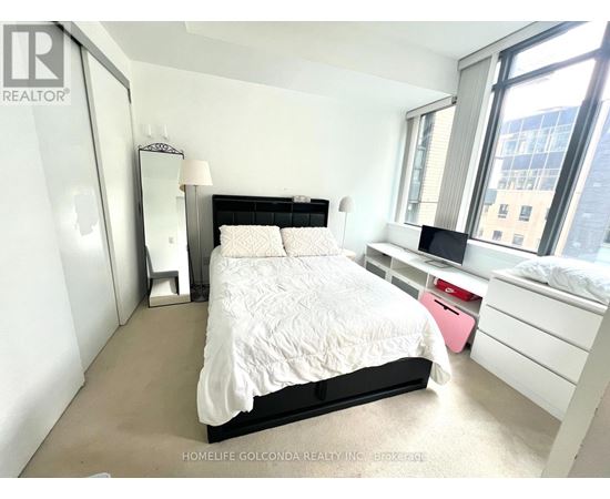 A bedroom with a large bed and a window.