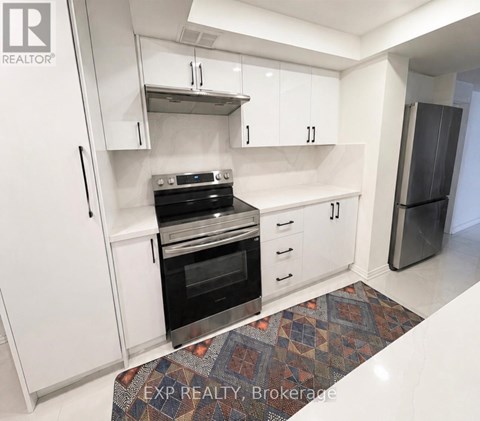 A kitchen with white cabinets and a black stove top oven.