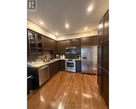 A kitchen with wooden floors and stainless steel appliances.