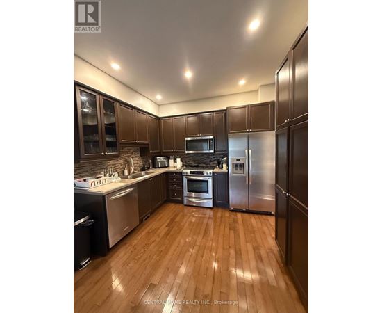 A kitchen with wooden floors and stainless steel appliances.