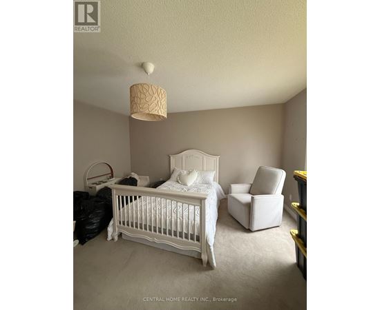 A white bedroom with a white bed and a white chair.