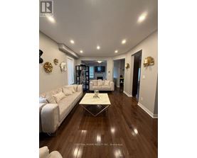 A spacious living room with a white sofa and a coffee table.