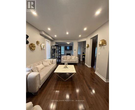 A spacious living room with a white sofa and a coffee table.