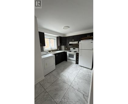 A kitchen with white appliances and black cabinets.