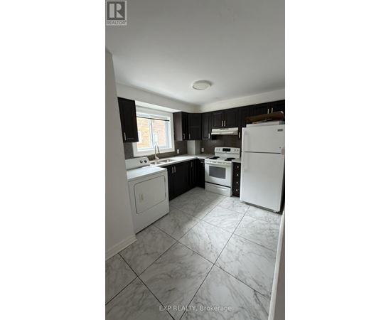 A kitchen with white appliances and black cabinets.