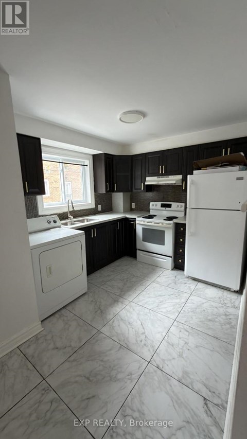 A kitchen with white appliances and black cabinets.