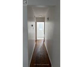 A hallway with a white door at the end.