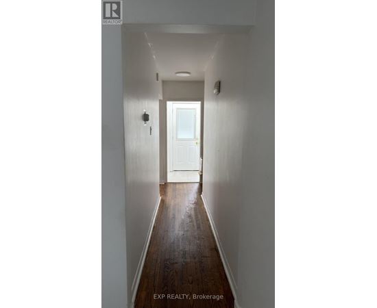 A hallway with a white door at the end.