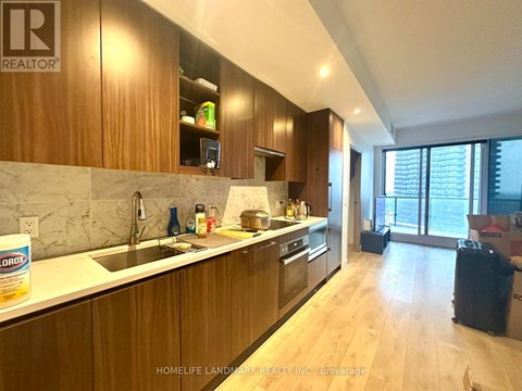 A kitchen with wooden cabinets and a marble countertop.