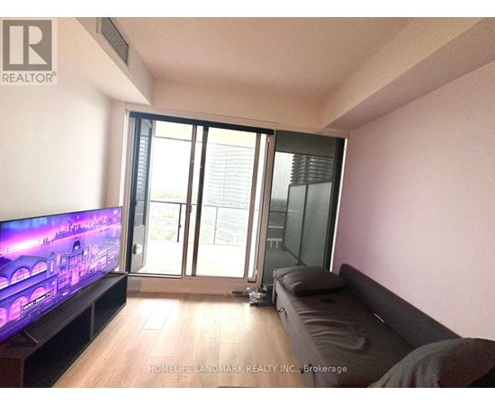 A living room with a flat screen TV and sliding glass doors.