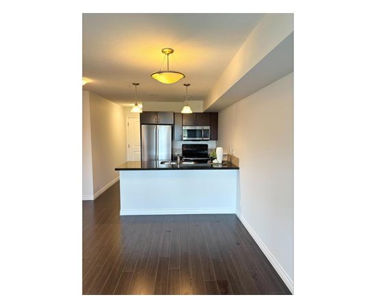 A modern kitchen with a white island and stainless steel appliances.