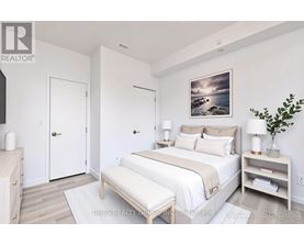 A bedroom with a bed, nightstand, and a painting on the wall.