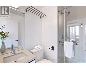 A bathroom with a glass shower door and a white toilet.