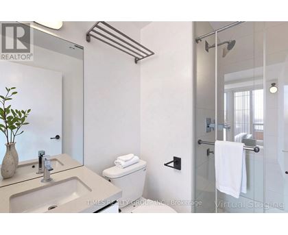A bathroom with a glass shower door and a white toilet.