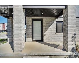 A modern house entrance with a glass door and a brick pillar.