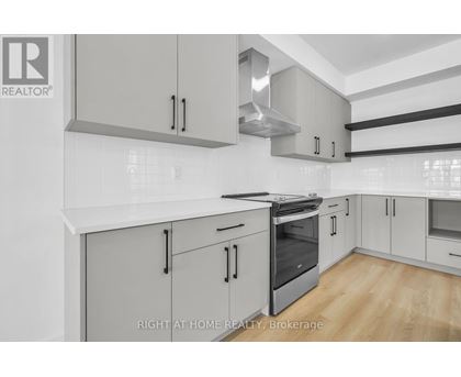 A modern kitchen with white cabinets and stainless steel appliances.