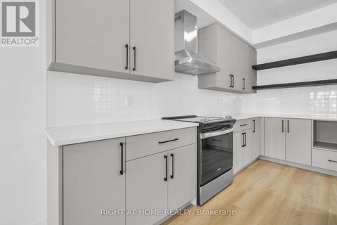 A modern kitchen with white cabinets and stainless steel appliances.