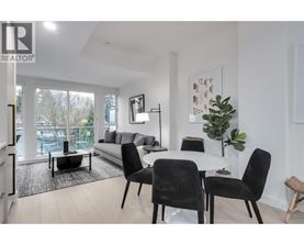 A living room with a white couch, a coffee table, and a dining table with chairs.