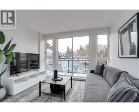 A living room with a grey couch and a black coffee table.
