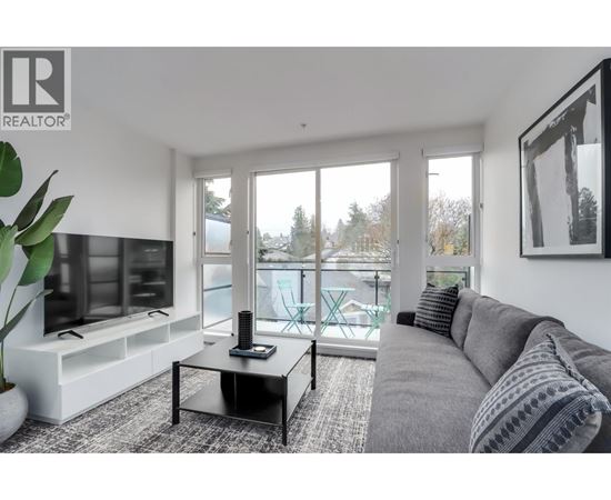 A living room with a grey couch and a black coffee table.