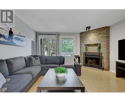 A living room with a grey couch and a fireplace.