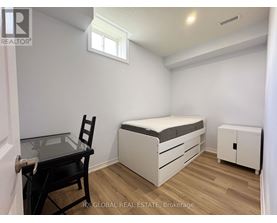A bedroom with a bed, chair, and cabinet.