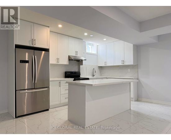 A modern kitchen with white cabinets and a stainless steel refrigerator.