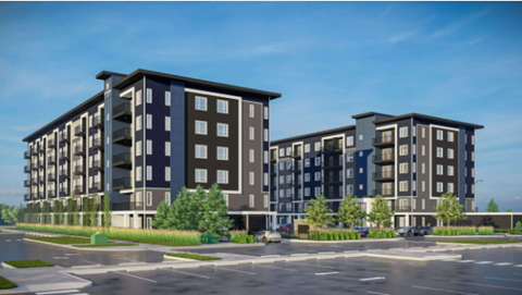 A modern apartment building with a parking lot in front.